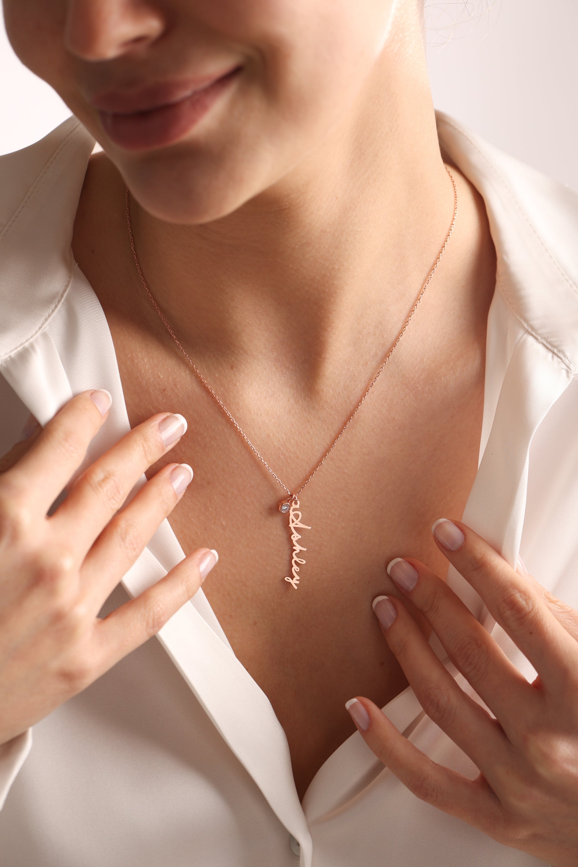 The name necklace in the photograph is made of 14k rose gold. The name pendant measures 35 mm in length, with an average width of 9 mm for capital letters and between 3 mm to 5 mm for lowercase letters. The dimensions may vary depending on the name you choose.